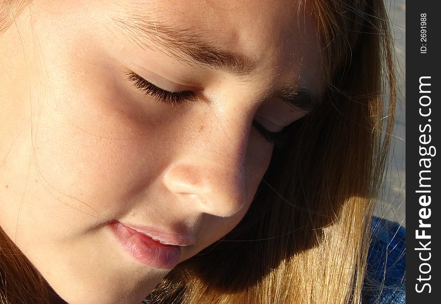 Serious expression on a close up of a girl on the beach. Serious expression on a close up of a girl on the beach