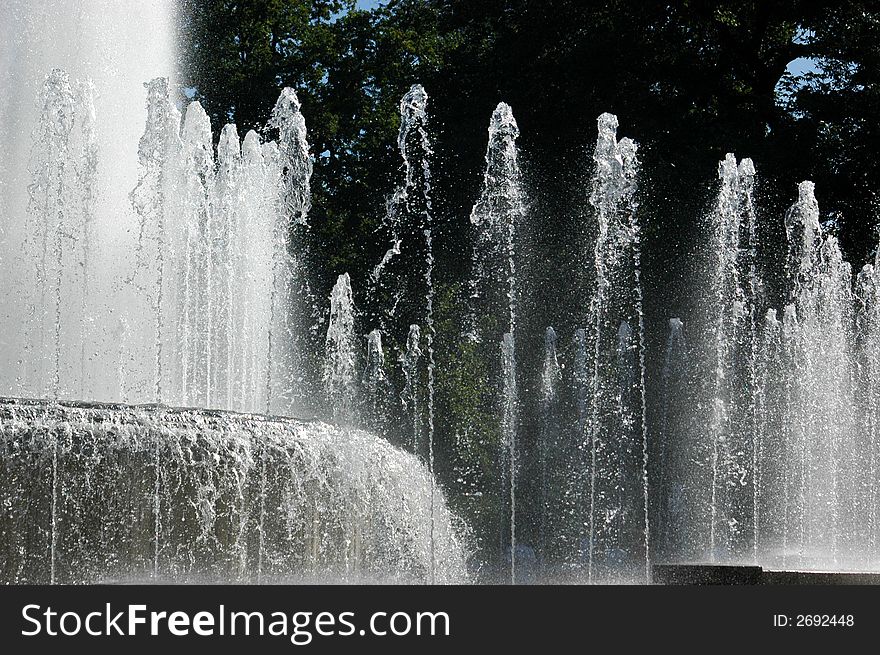 Water of a city fountain with trees in background. Water of a city fountain with trees in background