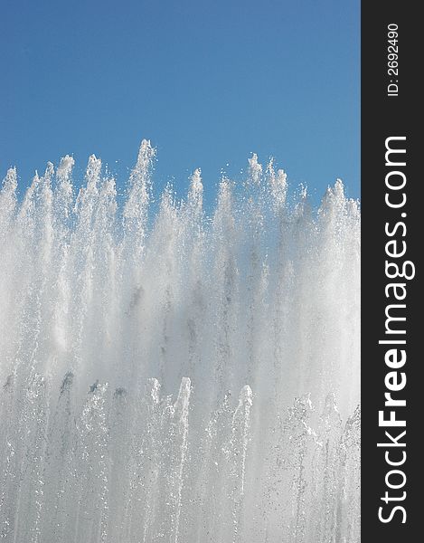 Water of a city fountain under blue sky