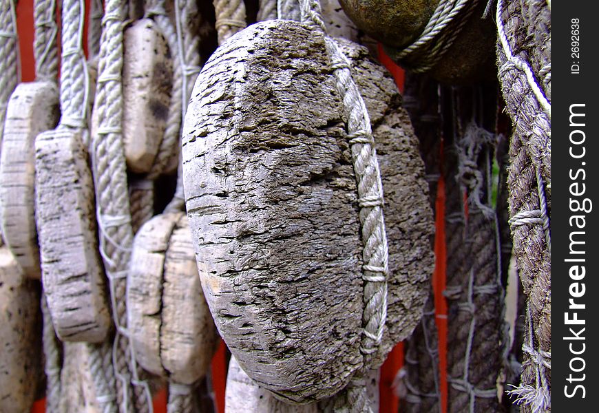 An ancient fishingnet hanging from the roof of a red woodenhouse, Sweden with some cork as floating buoys. An ancient fishingnet hanging from the roof of a red woodenhouse, Sweden with some cork as floating buoys.