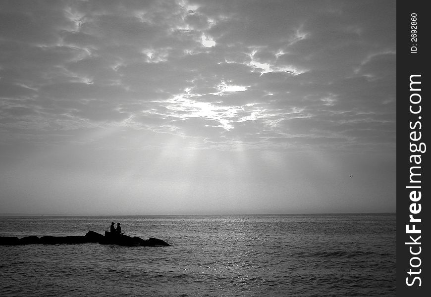 Lovers sit on rocks with lake view. Lovers sit on rocks with lake view