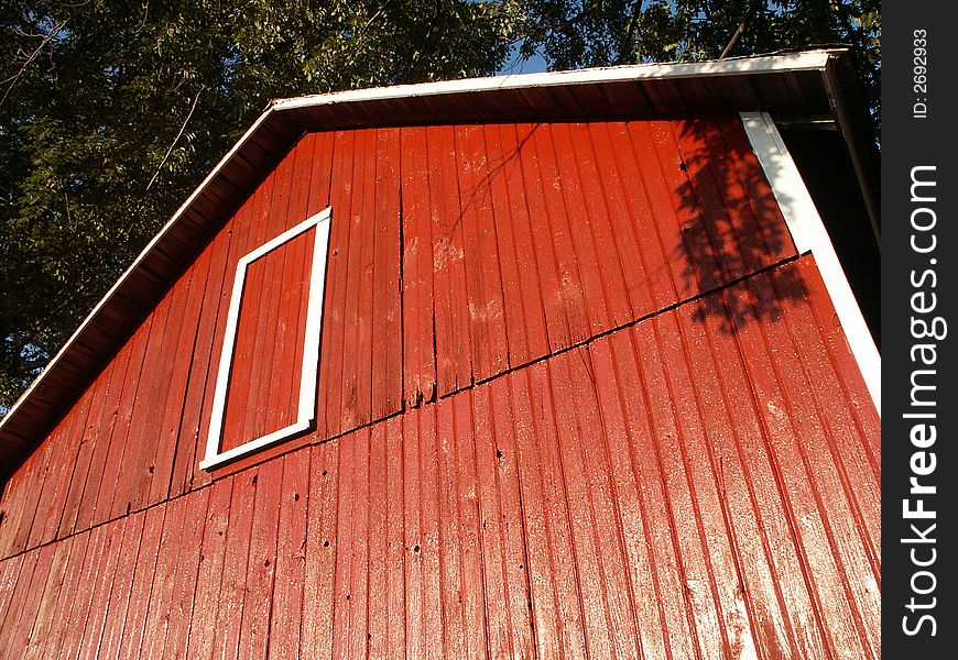 Dramatic view of red barn with warm summer sun