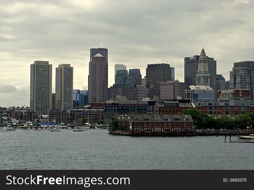 View of the boston skyline from boston harbor showing various skyscrapers from different eras. The sea is choppy and the sky cloudy. View of the boston skyline from boston harbor showing various skyscrapers from different eras. The sea is choppy and the sky cloudy