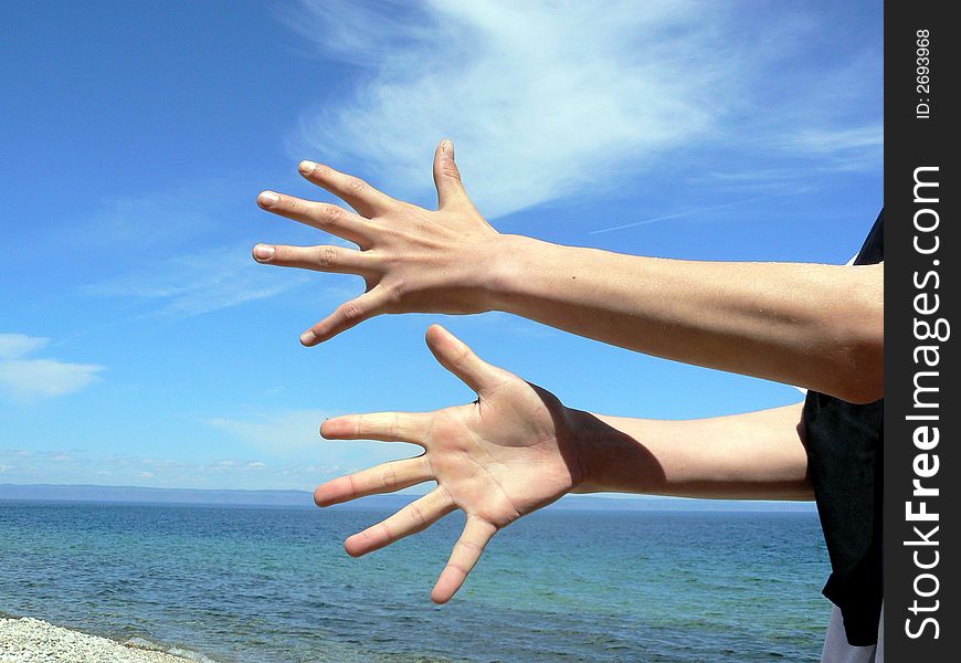Two hands on a background of the sea