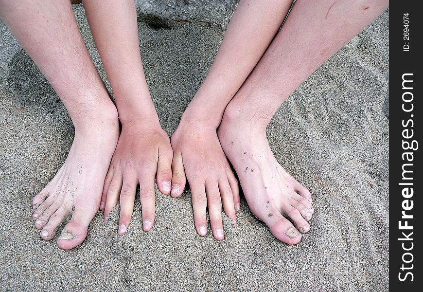 Two hands and two legs on sand. Two hands and two legs on sand