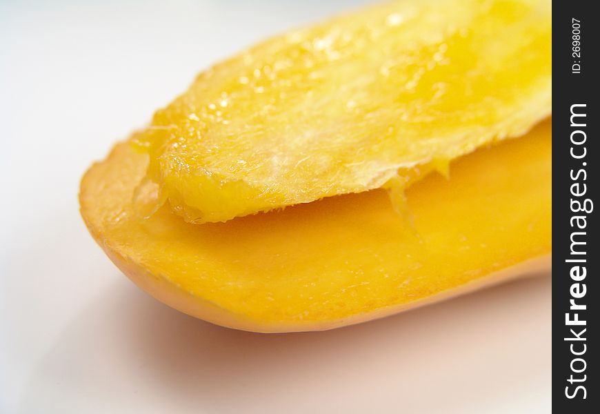 Sweet juicy champagne mango slice close-up with seed. Sweet juicy champagne mango slice close-up with seed