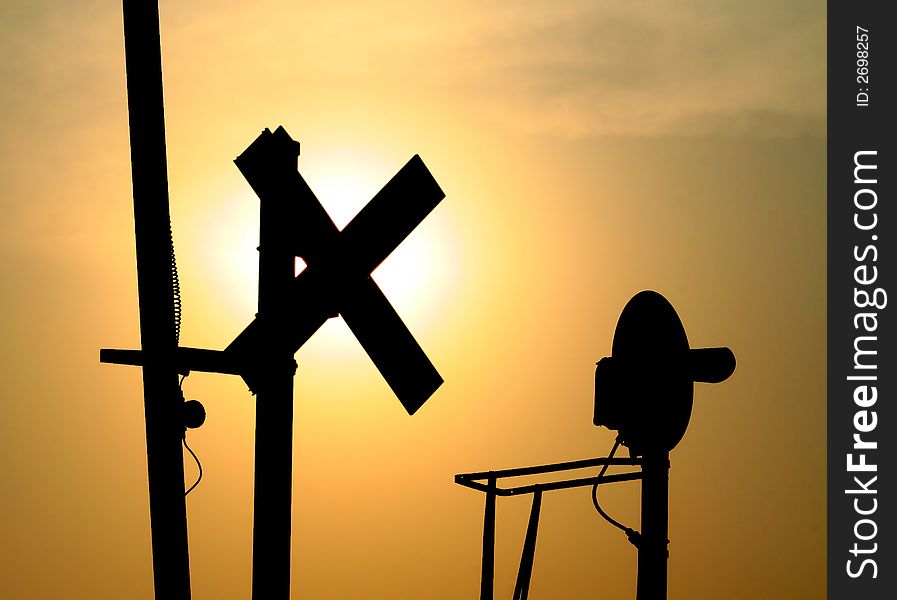 A crossing signal set in silhouette at dusk. A crossing signal set in silhouette at dusk