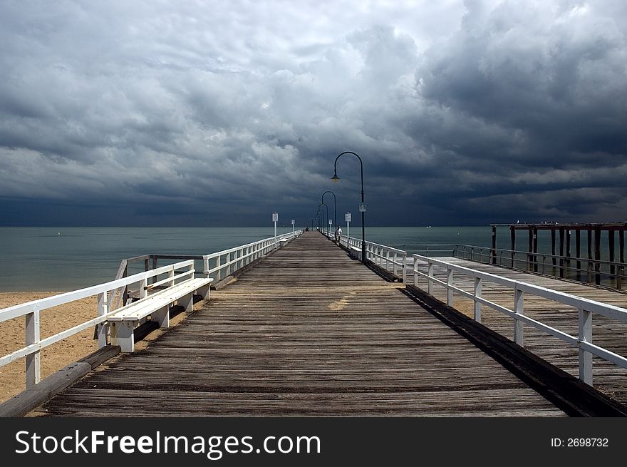Looking down a jetty at an approaching storm. Looking down a jetty at an approaching storm
