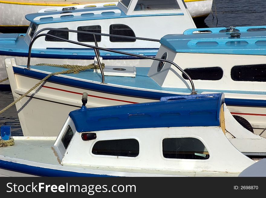 Three blue and white fishing boats in harbour. Three blue and white fishing boats in harbour