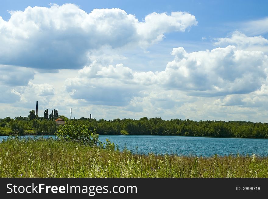 Colorful grass, lake, forest and cloudscape. Colorful grass, lake, forest and cloudscape
