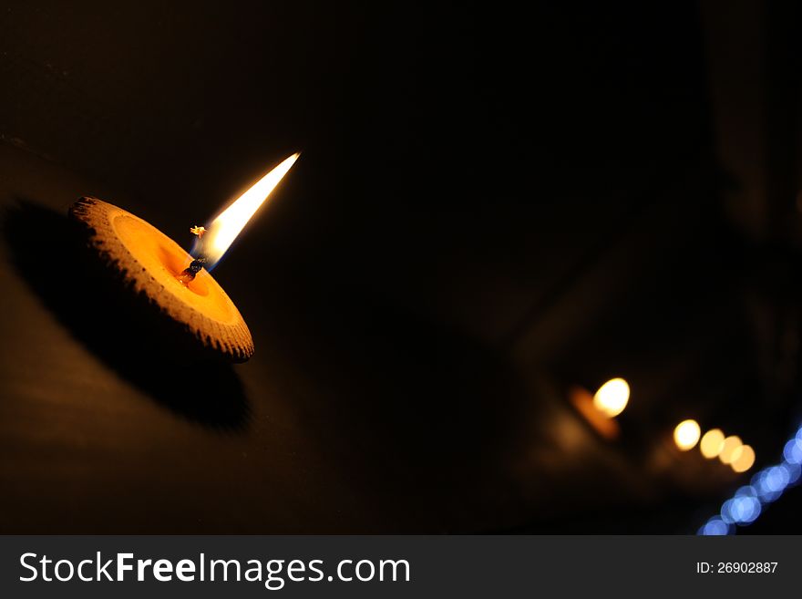 Line of burning candles on black background.