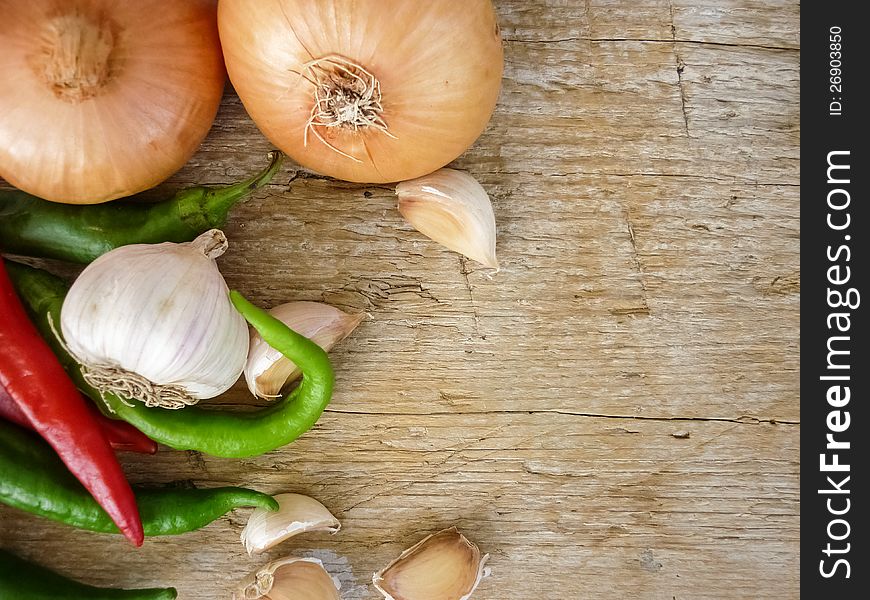 Still life garlic pepper onion on a wooden surface. Still life garlic pepper onion on a wooden surface