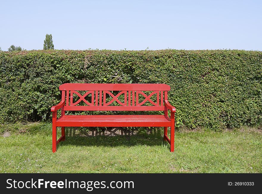 Closeup of a red empty bench in a park