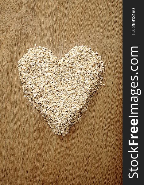 Heart shape oatmeal on wooden background. Good for healty food concept