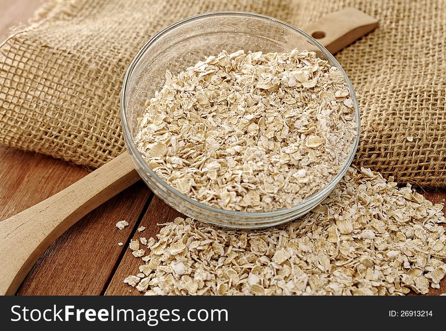 Oatmeal in glass bowl. Shot with wooden background and burlap