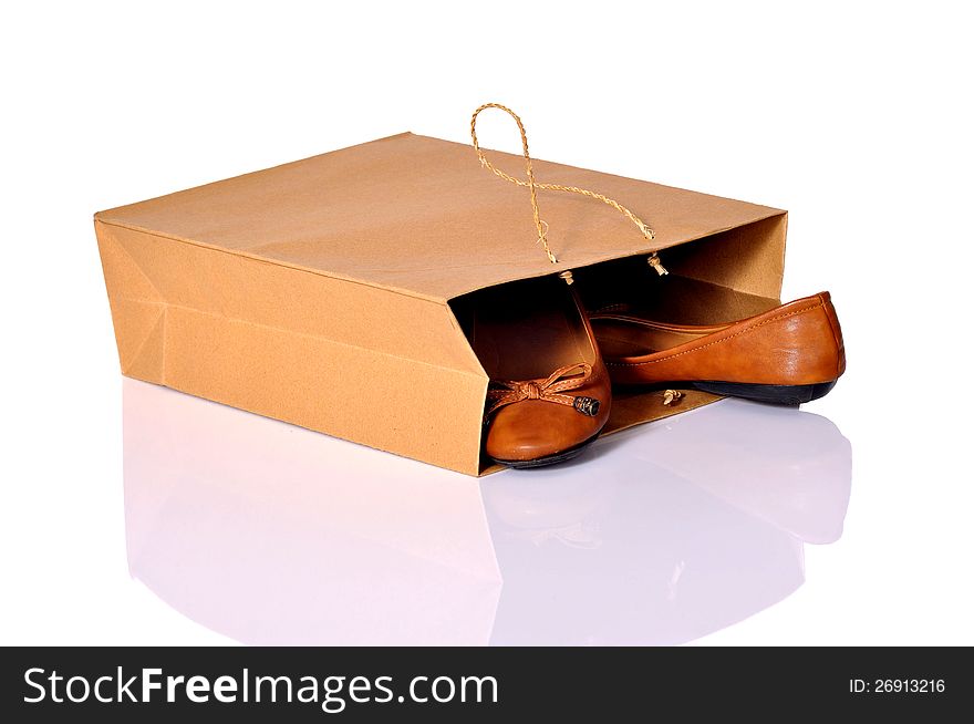 Brown shoes inside brown shopping bag over white background. Brown shoes inside brown shopping bag over white background