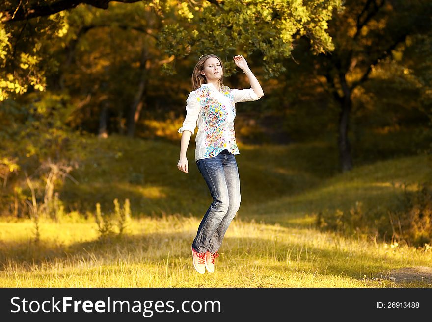 Young pretty woman jumping in the autumn park. Young pretty woman jumping in the autumn park