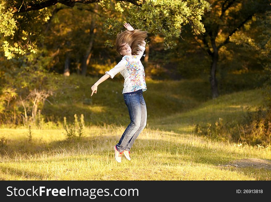 Young pretty woman jumping in the autumn park. Young pretty woman jumping in the autumn park