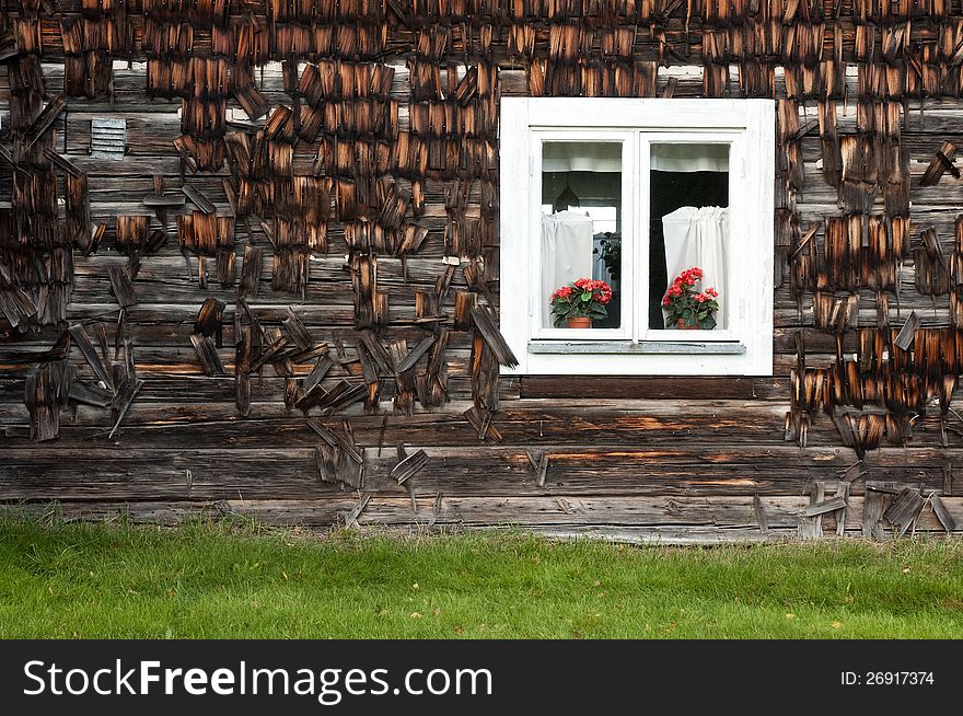 Old house wall with a windows and flowers.