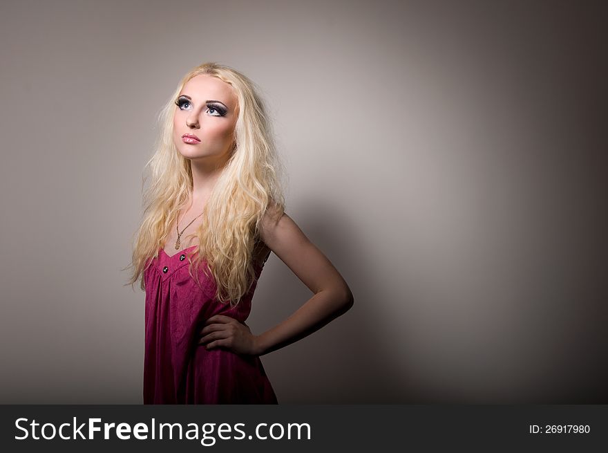 Blonde with a bright professional make-up on grey background. Blonde with a bright professional make-up on grey background