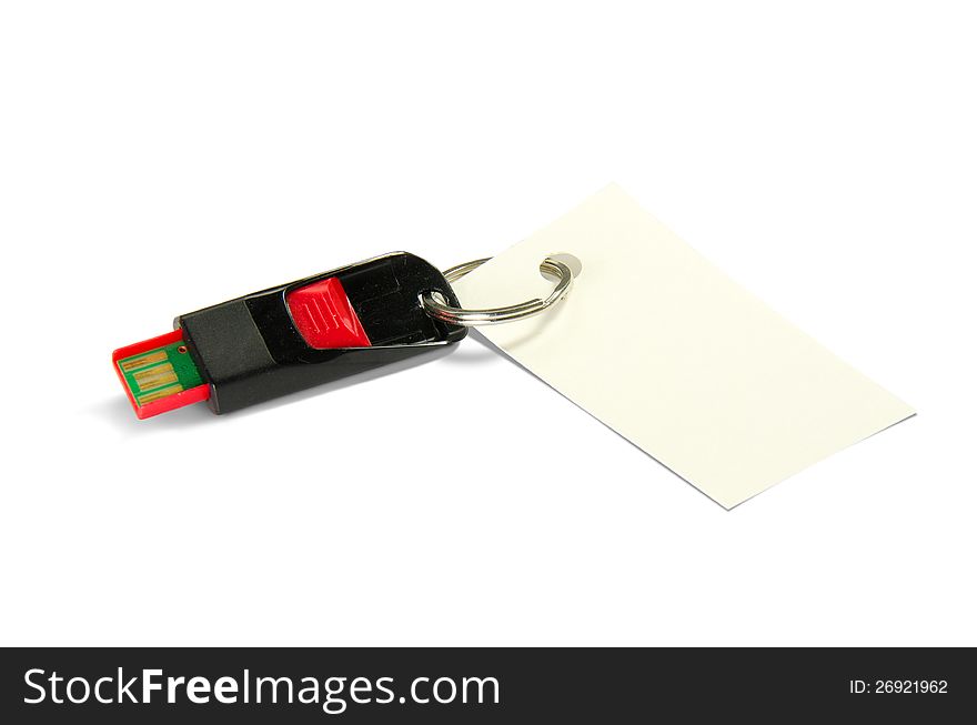 A black and red USB flash thumb drive with a blank card attached with a ring on a white background. A black and red USB flash thumb drive with a blank card attached with a ring on a white background