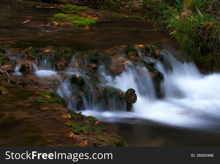 Peacefully Flowing Stream And Autumn Foliage