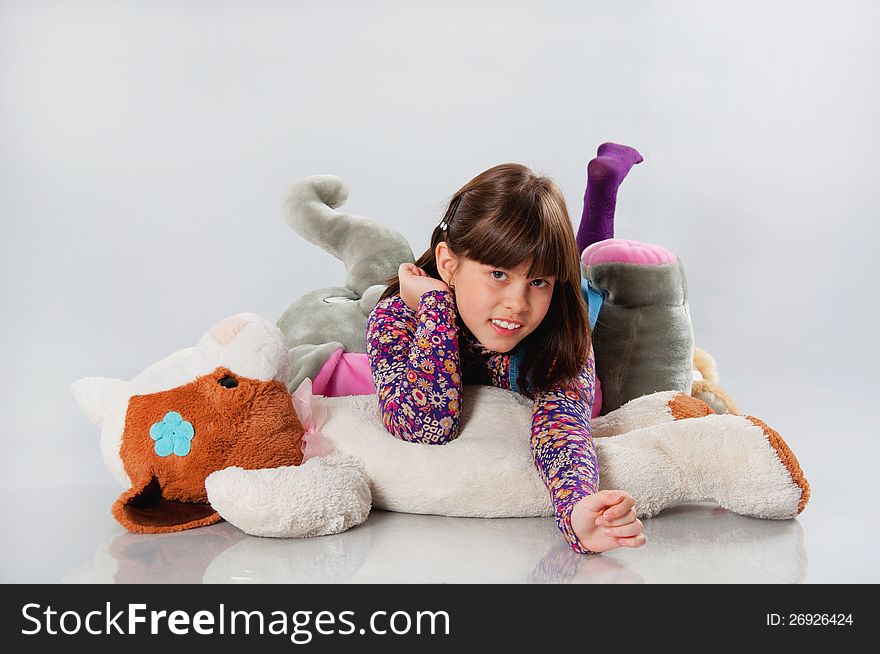 Cheerful girl playing with his toys on white background