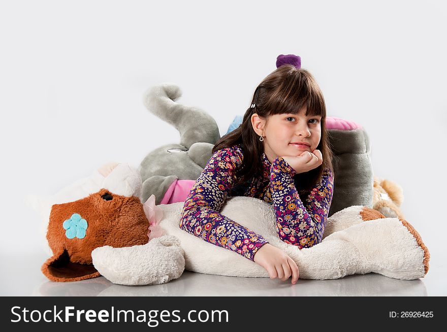 Cheerful girl playing with his toys on white background