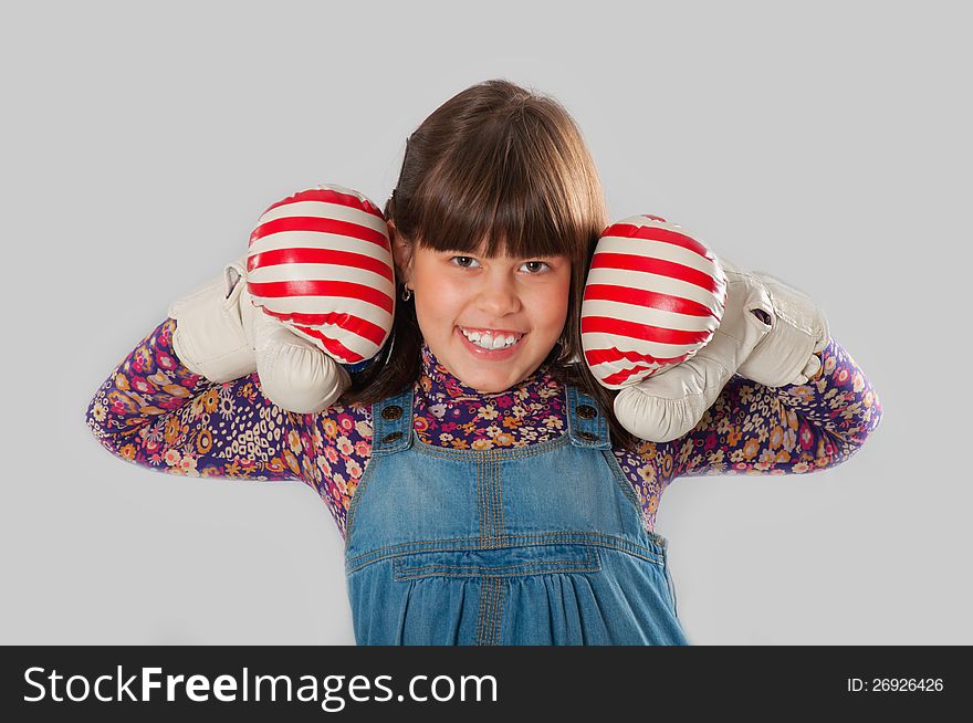 Cheerful girl with a boxing gloves in colorful dress