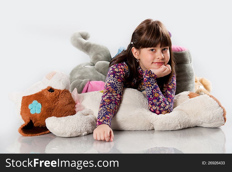 Cheerful girl playing with an elephant toy on white background