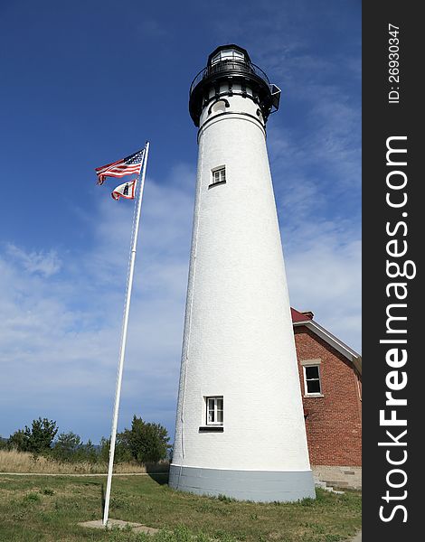 White lighthouse on the shore of Lake Superior with the American Flag. White lighthouse on the shore of Lake Superior with the American Flag