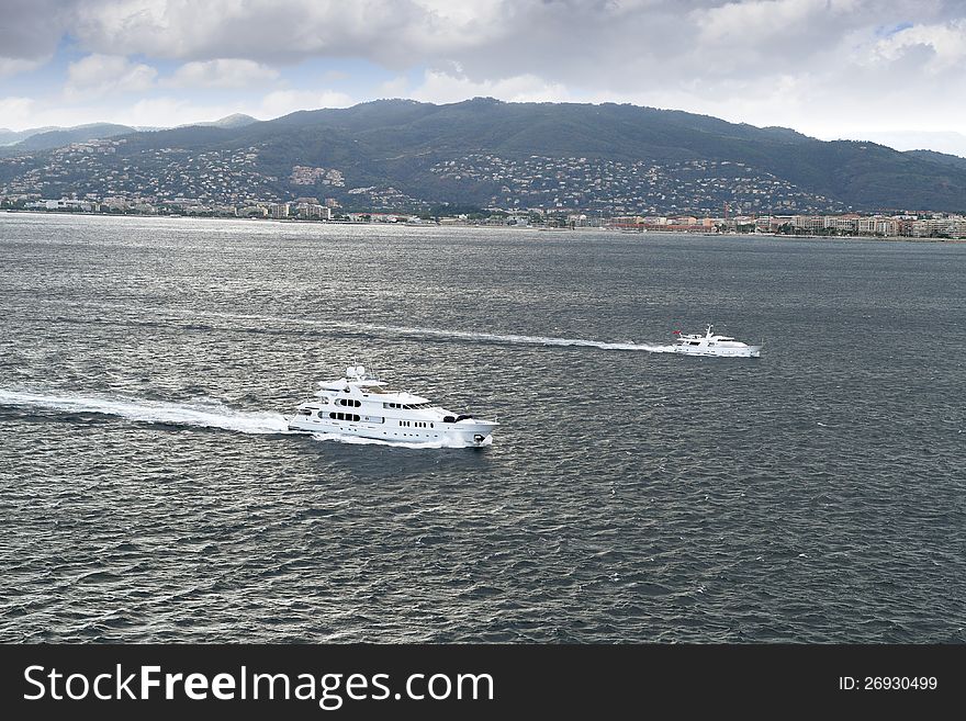 Group of luxury yachts sailing close to Cannes coast, France.