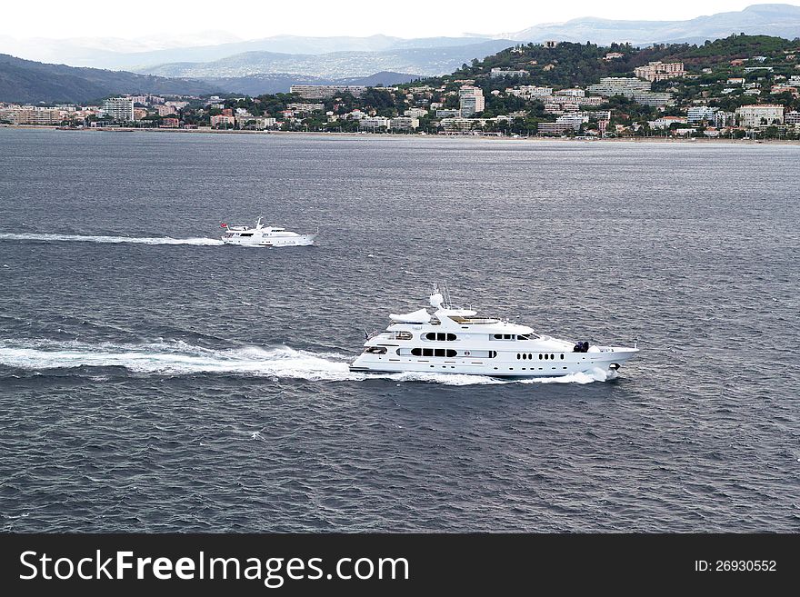 Group of luxury yachts sailing close to Cannes coast, France.