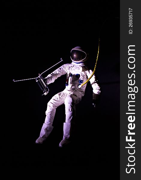 Astronaut wearing a pressure suit against a black background