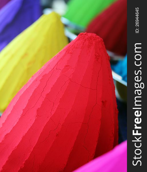 Piles and mounds of colorful dye powders for holi festival & other religious purposes being sold in indian market. The powders include kumkum(vermillion) in brilliant red, haldi in bright yellow, etc. Piles and mounds of colorful dye powders for holi festival & other religious purposes being sold in indian market. The powders include kumkum(vermillion) in brilliant red, haldi in bright yellow, etc