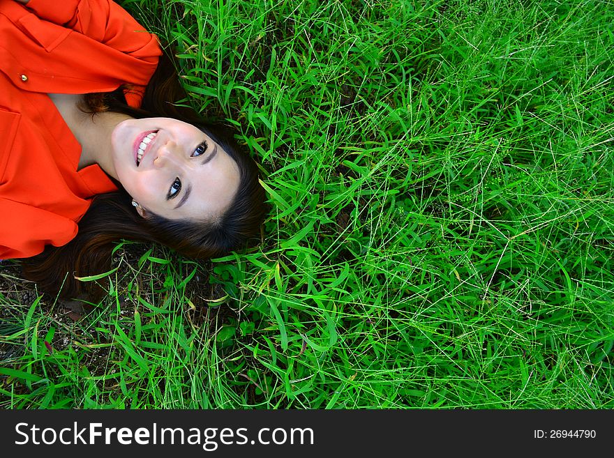 Smiling woman relaxes on the grass with copyspace. Smiling woman relaxes on the grass with copyspace