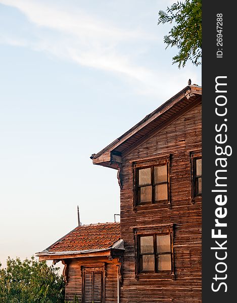 Vertical photo of a wooden house against blue sky.