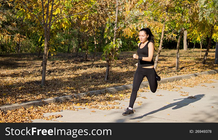 Attractive fit woman athlete running at speed along a rural lane through a park with copyspace. Attractive fit woman athlete running at speed along a rural lane through a park with copyspace