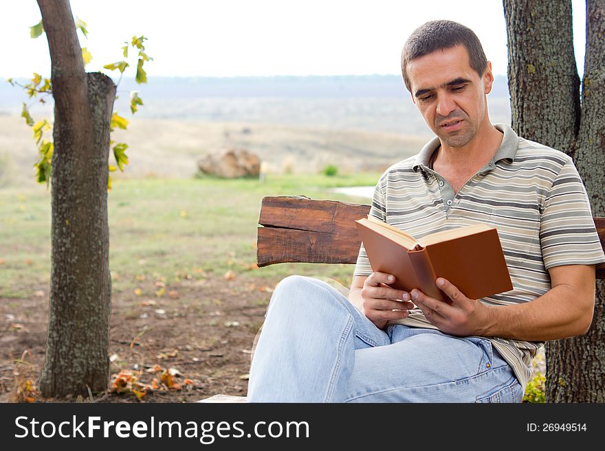 Man Enjoying A Book In The Garden