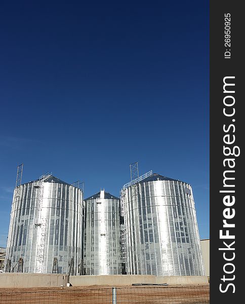 Metal silos on a clear blue sky background. Metal silos on a clear blue sky background