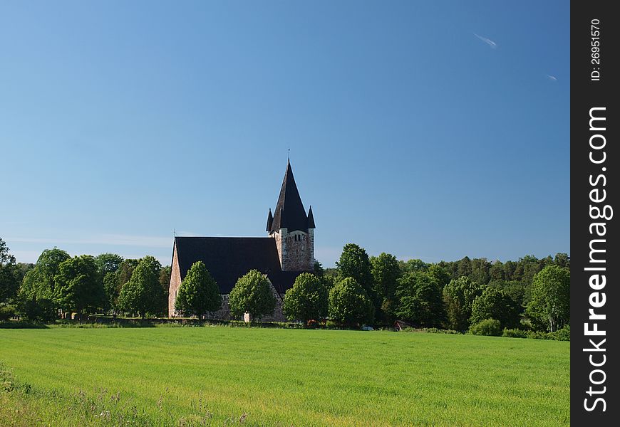 A church building in the field on a sunny day