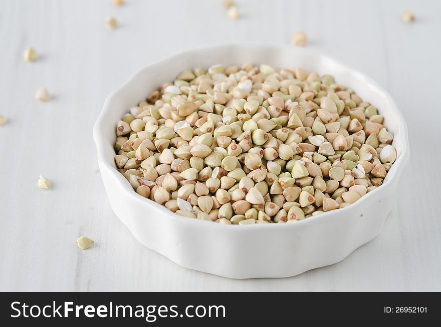 Green buckwheat in a white bowl on a white background