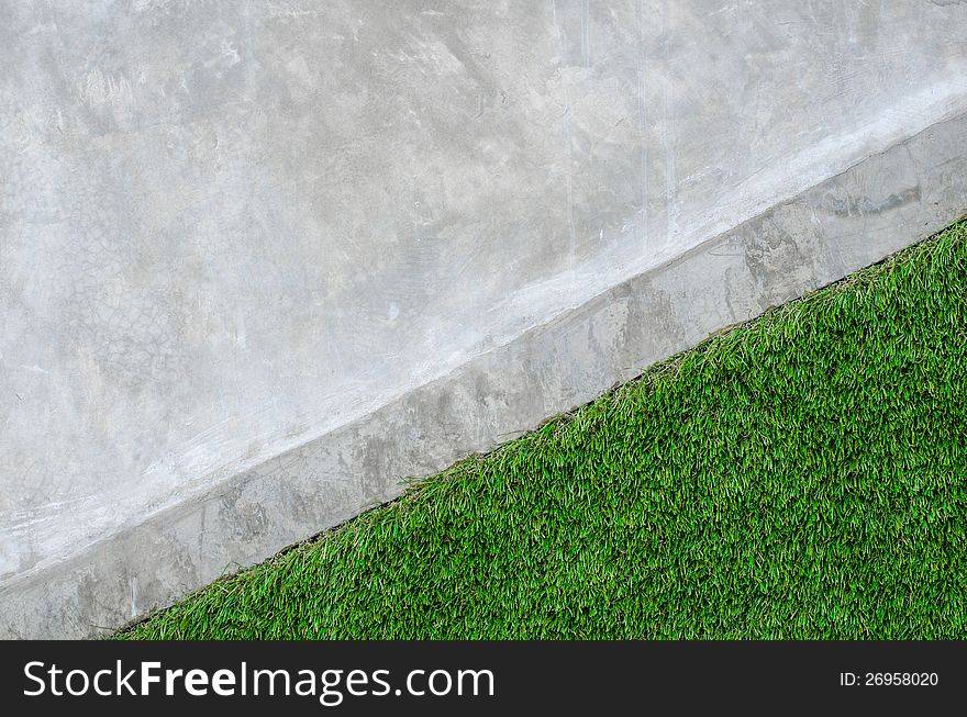 Artificial grass on a cement wall background