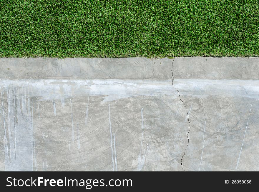 Artificial grass on a cement wall background