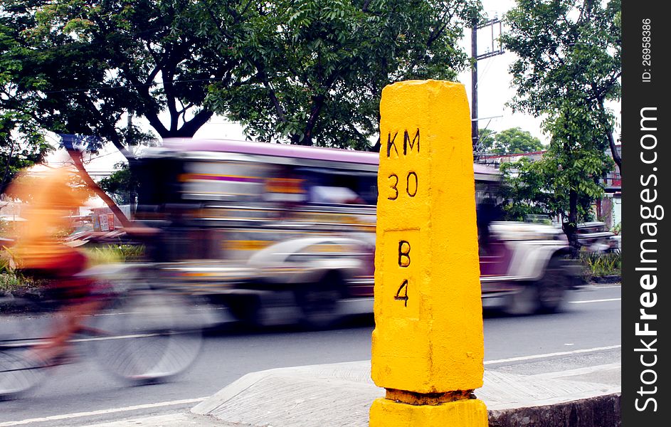 Concrete kilometer post showing the next town distance