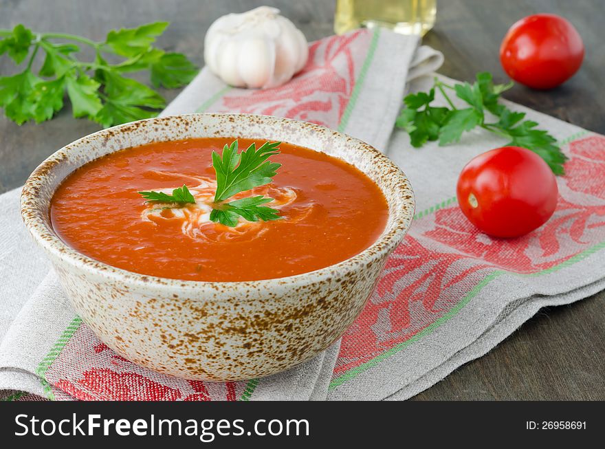 Hot tomato soup in ceramic bowl on the table, on a napkin, horizontal