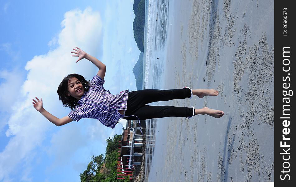 A young girl jumping on beach to describe happiness.