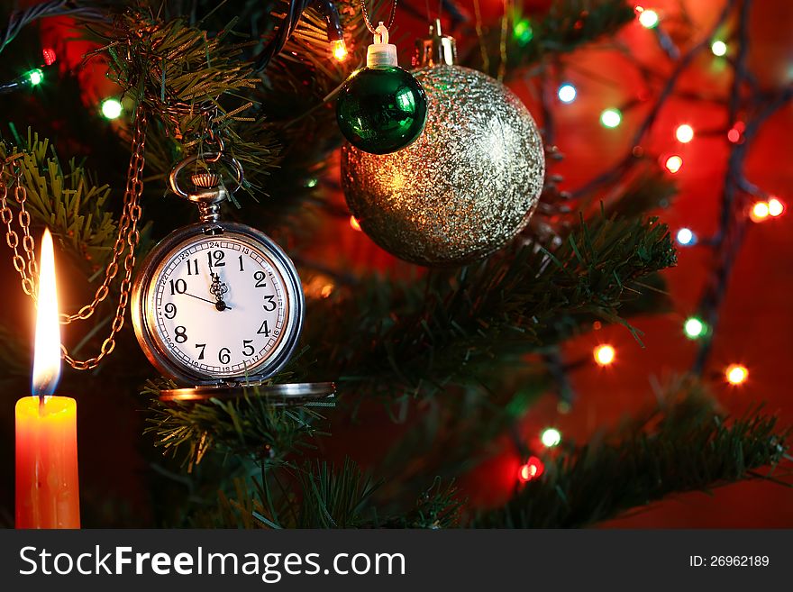 Vintage pocket watch hanging on Christmas tree near lighting candle. Vintage pocket watch hanging on Christmas tree near lighting candle