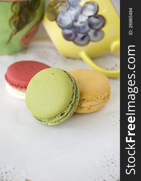 French macarons with colorful cups background