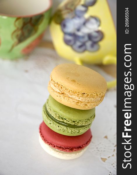 Stack of colorful macarons with colorful cups background